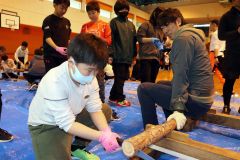 丸太を切り出す体験をする児童
