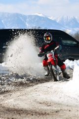 雪を豪快に蹴散らし、爽快に走るライダー