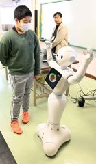 自分が作ったプログラム通りに動くロボットを見る児童