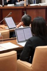 タブレットを使って書類を読む議員ら
