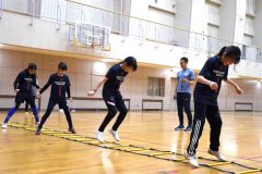 小西康道監督（奥）からトレーニングを通じて体の使い方を学ぶ団員たち