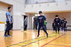 小西康道監督（左）からトレーニングを通じて体の使い方を学ぶ団員たち