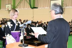 田中学長から卒業証書・学位記を受ける社会福祉科介護福祉専攻総代の岸塚さん（１５日午前１０時５０分ごろ、帯広大谷短大アリーナ）