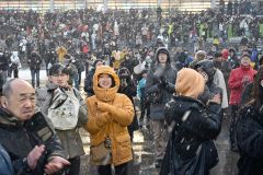 最後の馬がゴールし、拍手する観客