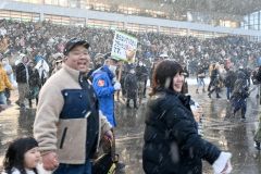 走る馬を追いながら応援する観客