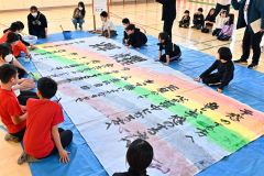 卒業制作で書道パフォーマンスに挑戦する児童（金野和彦撮影）