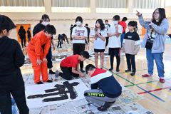 卒業制作で書道パフォーマンスに挑戦する児童（金野和彦撮影）
