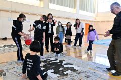 卒業制作で書道パフォーマンスに挑戦する児童（金野和彦撮影）