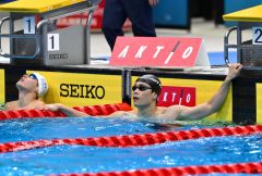 男子１００メートル自由形・決勝で、６位に終わった坂田怜央（右）。レース後、電光掲示板に表示されたタイムを見つめる坂田（金野和彦撮影）
