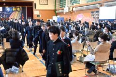 在校生や保護者らに見送られながら退場する卒業生（２２日、帯広若葉小学校で。須貝拓也撮影）