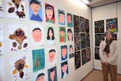 自画像や花火を描いた作品など子どもたちの絵画と並ぶ近藤さん