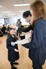 両親にそれぞれの似顔絵を贈った卒園児（２４日午前９時１５分ごろ、助川かおる通信員撮影）