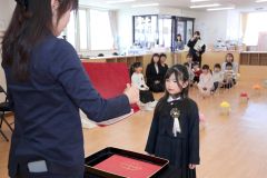 第一号の卒園証書を受け取る卒園児（２４日午前９時１０分ごろ、助川かおる通信員撮影）