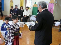 北原分団長（右）から修了証書を受け取る信乃ちゃん