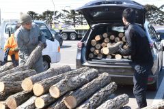 購入者の車にほだ木を積み込むスタッフ