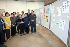 作品の横に並ぶ堀田代表（右）と会員ら
