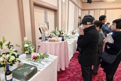 鈴木氏の写真に手を合わせる参加者