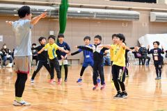 村田さん（左）とウオーミングアップする児童たち