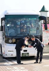 式典後、代行バスの運転士（左）に花束を贈る浜田正利新得町長（右）＝３１日、ＪＲ新得駅前で。金野和彦撮影