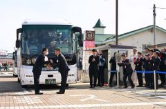式典後、代行バスの運転士（左）に花束を贈る浜田正利新得町長（右）＝３１日、ＪＲ新得駅前で。金野和彦撮影