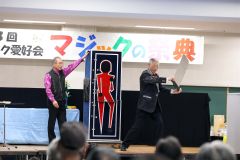中西宣夫会長（左）による大がかりな人体切断マジックもあった