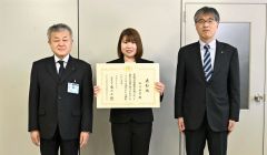 表彰状を持つ塩沢祐菜教諭（中央）、広瀬容孝教育長（左）、帯広若葉小の山田知史校長（右）