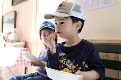 施設内で調理したシイタケをほうばる子ども