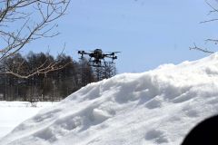 デモフライトで融雪剤を散布するドローン