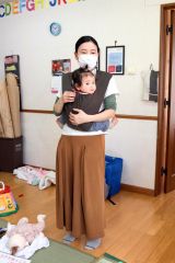 園にあった抱っこひもでレクチャーする阿部さん。泣いていた仁香ちゃんも“すっぽり”収まるとすぐに泣き止んだ