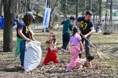 枝や枯れ葉などを拾い集める家族連れ（１４日、金野和彦撮影）