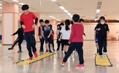 陸上クラブで小学生とともにトレーニングに励む中学生（左）