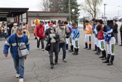 帯広競馬場の入場門で来場者を迎える騎手ら（１９日、須貝拓也撮影）