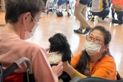 愛犬の「ララ」（中央）と新得町の指定障害者支援施設「屈足わかふじ園」に訪問した丸山さん（右）（１７日）