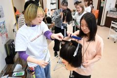 ヘアカット体験をする中高生ら