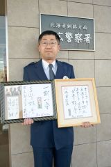 好楽さんから二つ目昇進を告げられた岡崎巡査長。手には昇進を告げる色紙と好楽さんが帯広署宛てに書いた色紙とメッセージを持っている