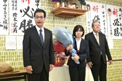 支持者の前であいさつをする田中氏（左）。中央は妻朋子さん。右は北藤選対本部長（２１日、午後９時半ごろ、広尾町内の選挙事務所で。金野和彦撮影）