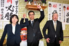 初当選を果たし、ガッツポーズをする田中氏（中央）。左は妻朋子さん。右は北藤選対本部長（２１日、午後９時１０分ごろ、広尾町内の選挙事務所で。金野和彦撮影）