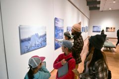 アラスカに暮らす野生動物の姿を捉えた星野氏の作品に見入る来場者（２０日、午前１０時４５分ごろ。金野和彦撮影）