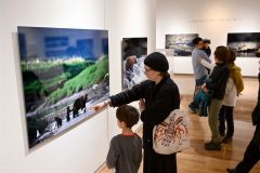 アラスカに暮らす野生動物の姿を捉えた星野氏の作品に見入る来場者（２０日、午前１０時ごろ。金野和彦撮影）
