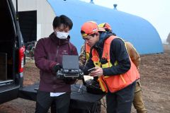 ドローンでシカを探す三浦代表と相談をする山川翔さん