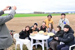 農場で焼いたピザを手に記念撮影。前列中央右がアマンダさん、中央左がマックスさん