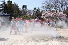 ミスト噴水で涼む園児（２６日、午前１０時４０分ごろ、音更町役間前で。金野和彦撮影）