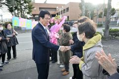 役場前に駆けつけた支援者と握手する村瀬優町長