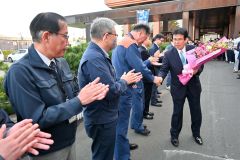 庁舎玄関前で、見送りの役場職員と握手する村瀬優町長