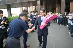 庁舎玄関前で、見送りの役場職員と握手する村瀬優町長