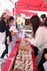 ＪＲ池田駅前の観光オープン式で、管内高校生が開発したバナナ饅頭味のマカロンを買い求める来場者（２７日午前１１時、助川かおる通信員撮影）