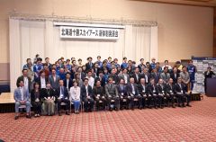 キックオフパーティーの参加者と記念写真に収まる（金野和彦撮影）