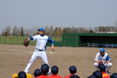 腰須永コーチ（左）から投球フォームの基礎を教えてもらう児童ら（右は市川コーチ）