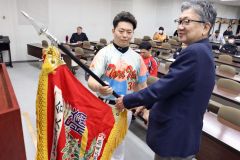 準優勝旗を返還する鶏の伊藤(左)と鈴木支部長