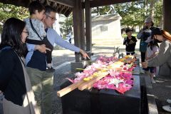 鮮やかな花手水を楽しむ親子連れ